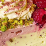 Saborea la dulce sinfonía de sabores en nuestro Cheesecake de frambuesa y limón con migas de pistacho. ¡Te espera un feliz bocado!